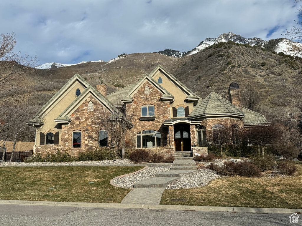 View of front of property with a mountain view and a front yard