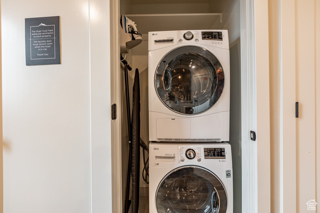 Clothes washing area featuring stacked washer and clothes dryer