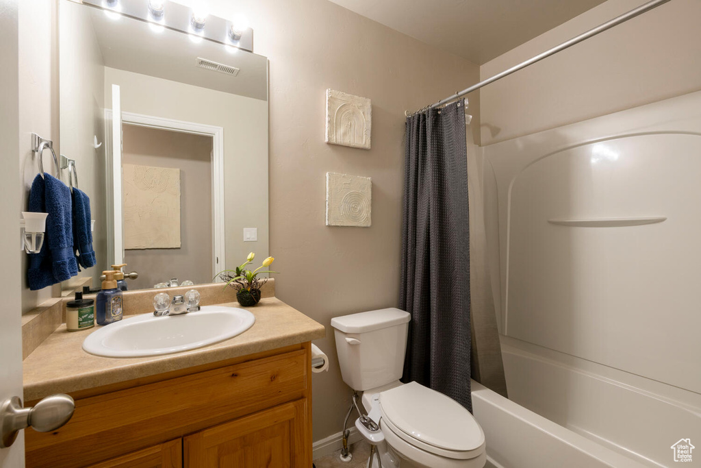 Full bathroom with vanity, toilet, and shower / tub combo with curtain