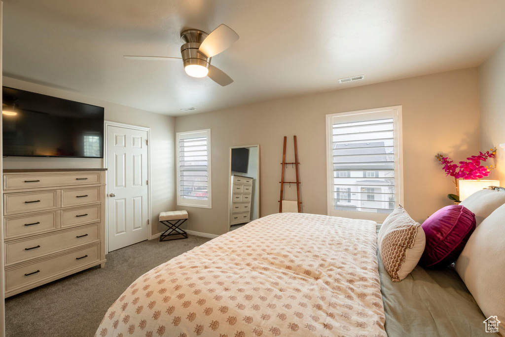 Carpeted bedroom featuring ceiling fan