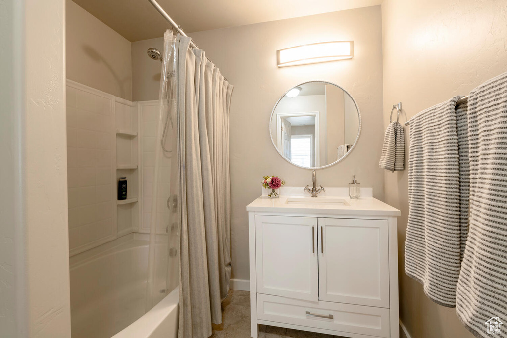 Bathroom with oversized vanity and shower / tub combo with curtain