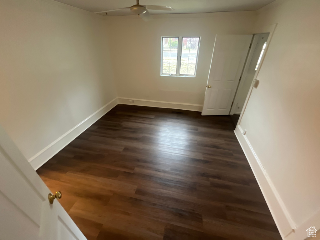 Spare room featuring ceiling fan and dark wood-type flooring