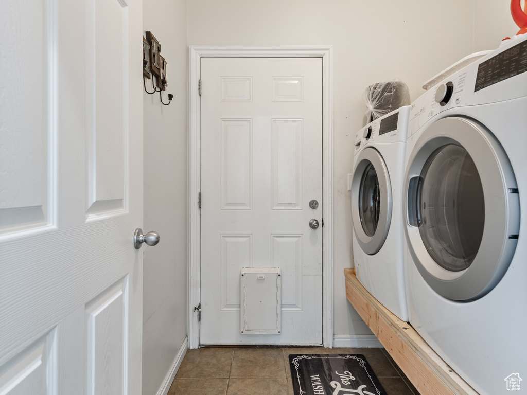 Laundry room featuring light tile floors and washer and dryer