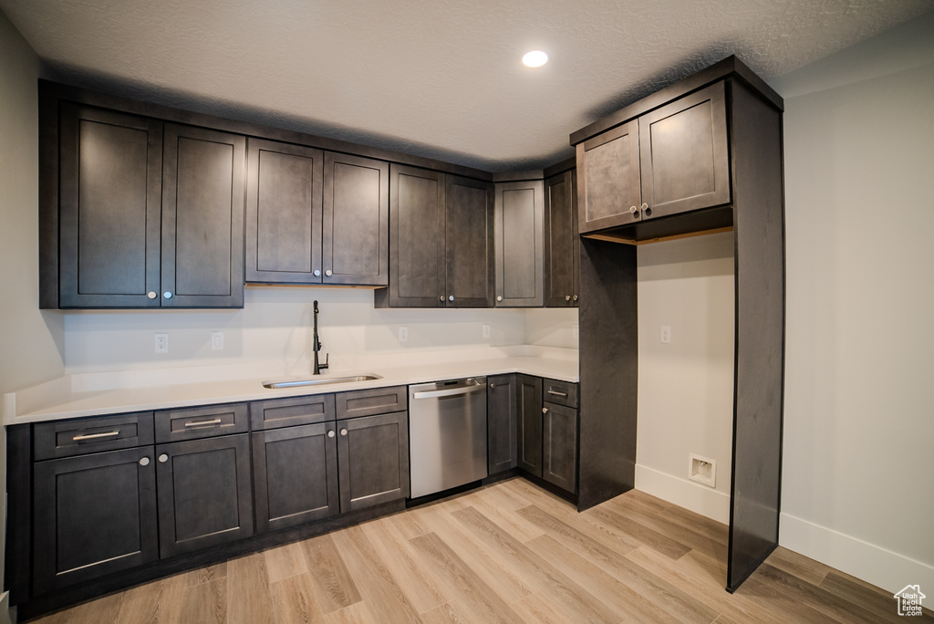 Kitchen featuring dark brown cabinetry, sink, a textured ceiling, dishwasher, and light hardwood / wood-style floors