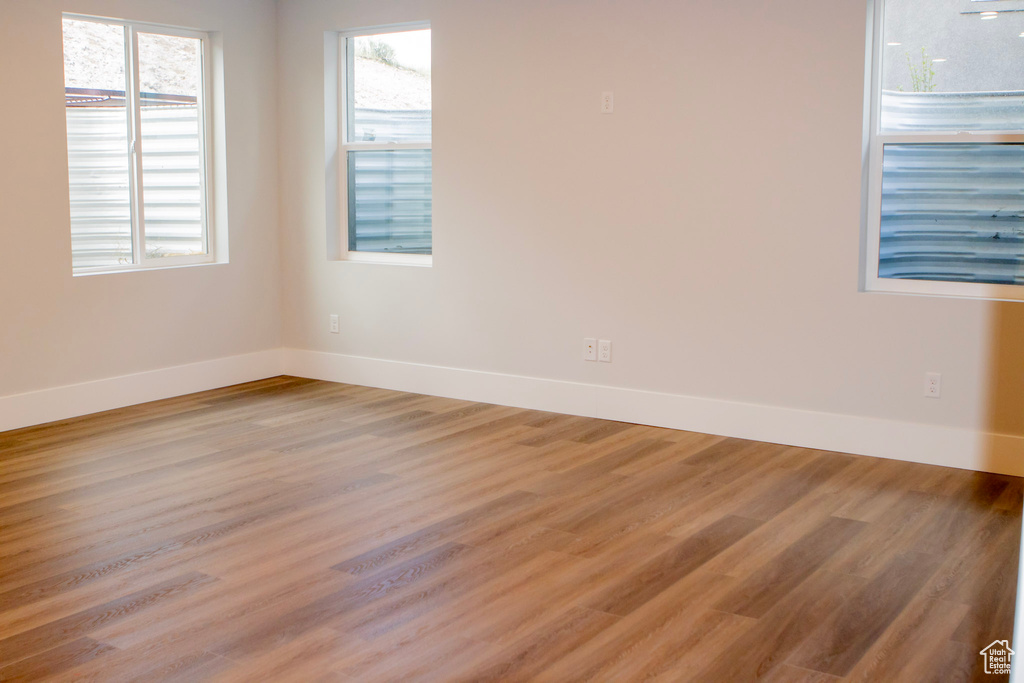 Unfurnished room with plenty of natural light and wood-type flooring