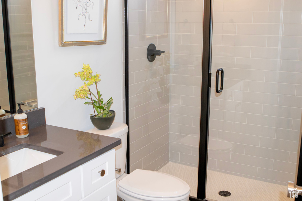 Bathroom with a shower with door, toilet, and vanity