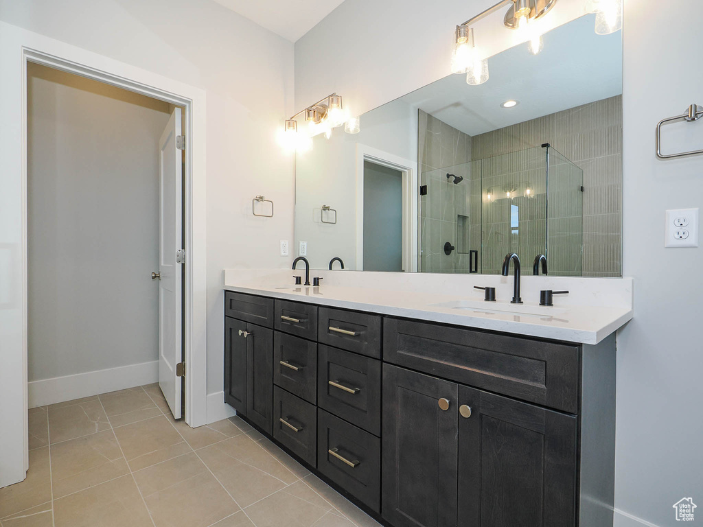 Bathroom with walk in shower, dual sinks, tile flooring, and large vanity