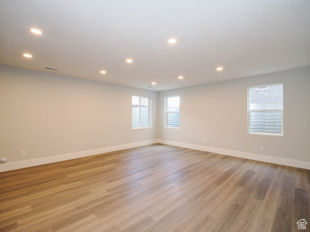 Empty room featuring a textured ceiling and light hardwood / wood-style floors