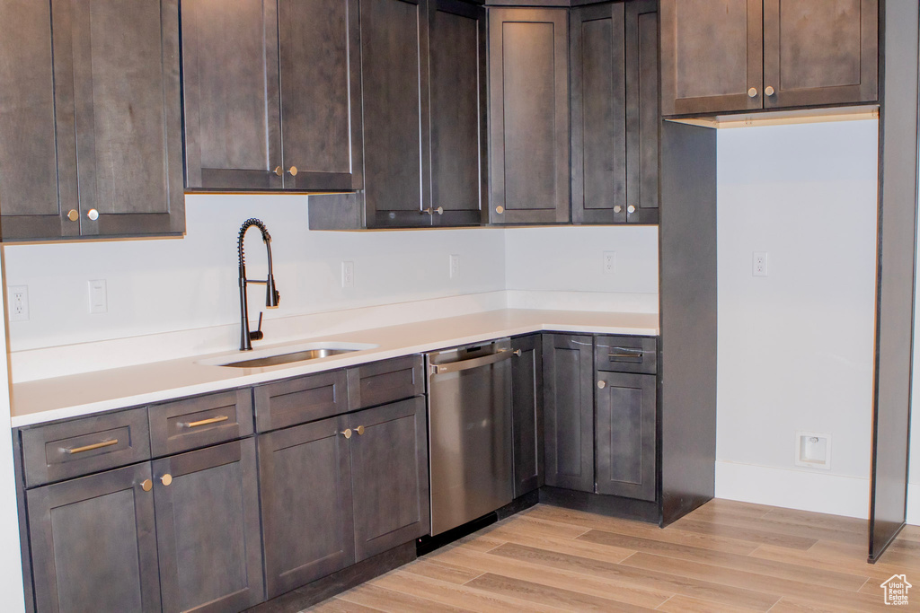 Kitchen with dark brown cabinetry, sink, dishwasher, and light hardwood / wood-style flooring