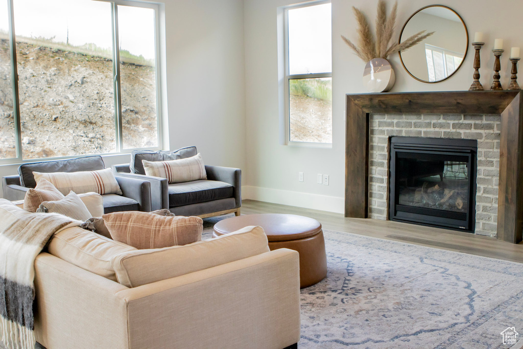 Living room with hardwood / wood-style flooring, a brick fireplace, and a wealth of natural light