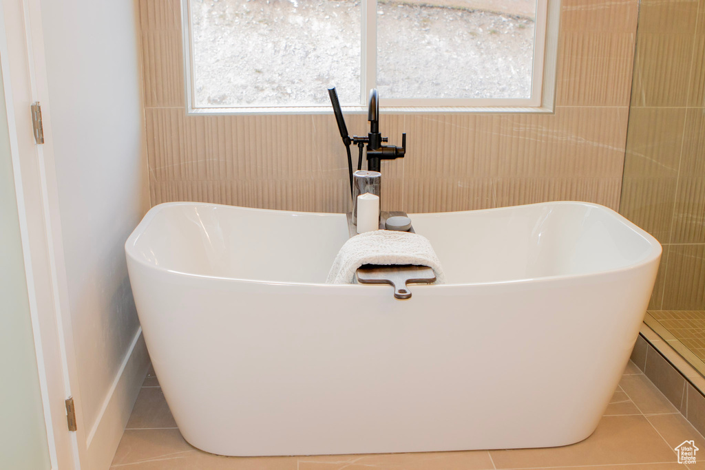 Bathroom with a bath and tile flooring