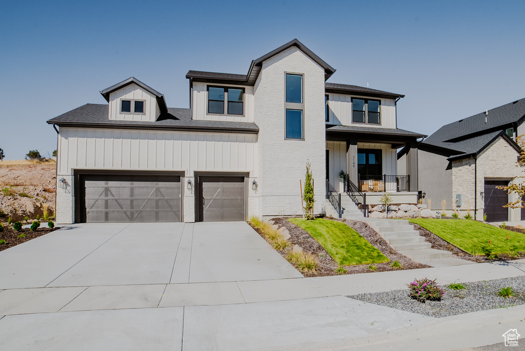 View of front of property with covered porch and a garage