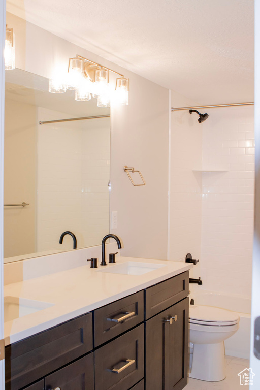 Full bathroom with double sink vanity, tile floors, toilet, and  shower combination