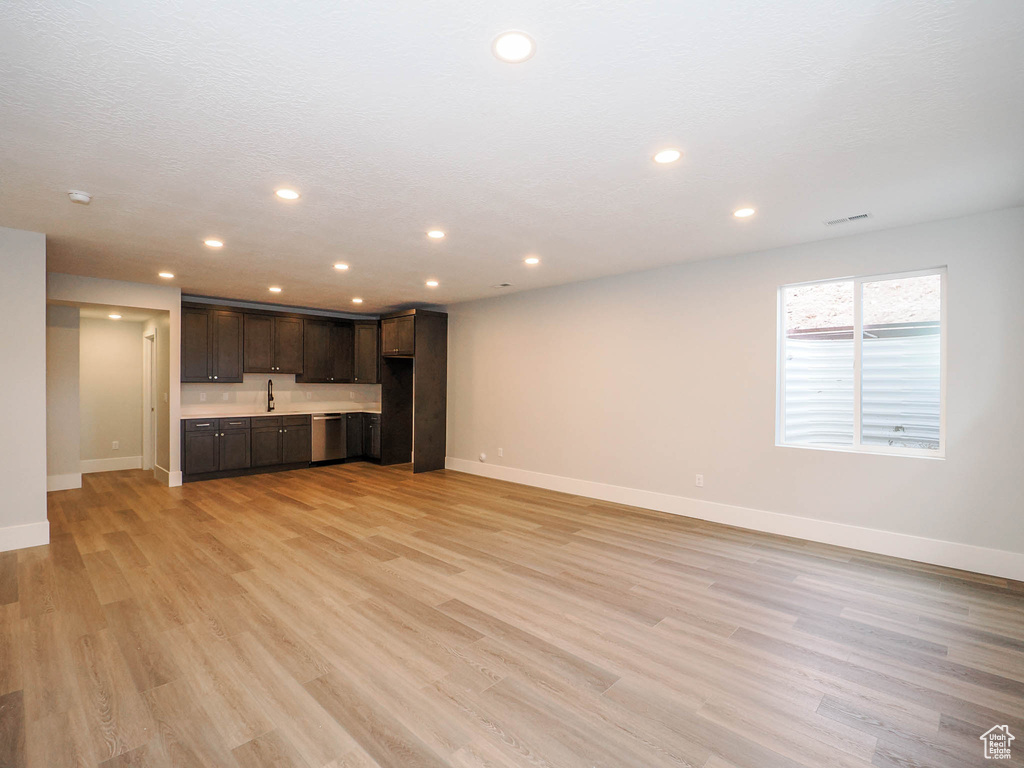 Unfurnished living room featuring light hardwood / wood-style floors and sink