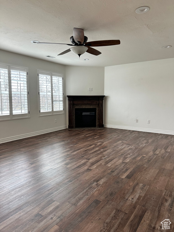 Unfurnished living room featuring dark wood-type flooring and ceiling fan