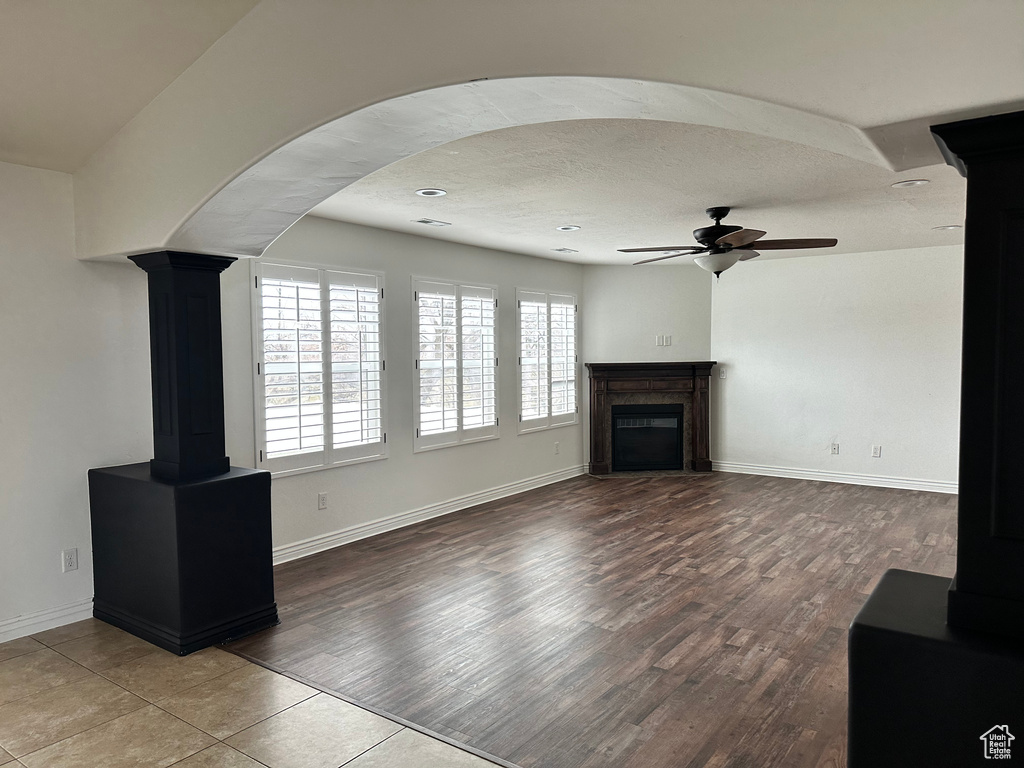 Unfurnished living room with tile floors and ceiling fan