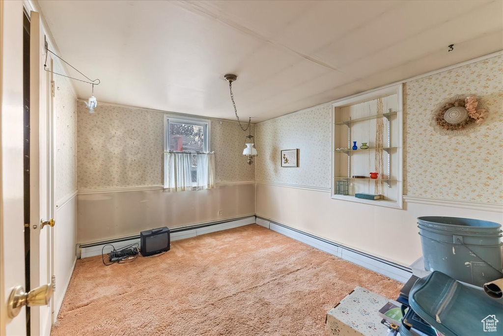Spare room with light colored carpet and a baseboard heating unit