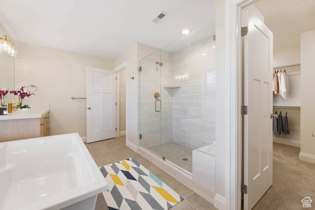 Bathroom featuring vanity, tile floors, and a shower with shower door