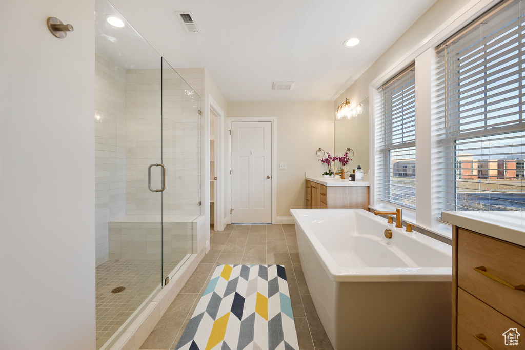Bathroom featuring tile flooring, plus walk in shower, and vanity