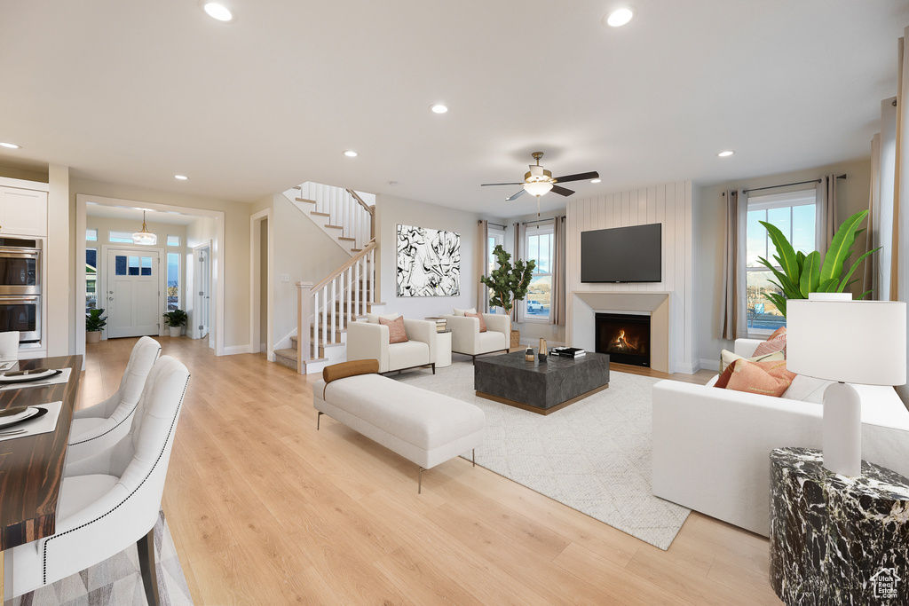 Living room with light hardwood / wood-style floors, plenty of natural light, and ceiling fan