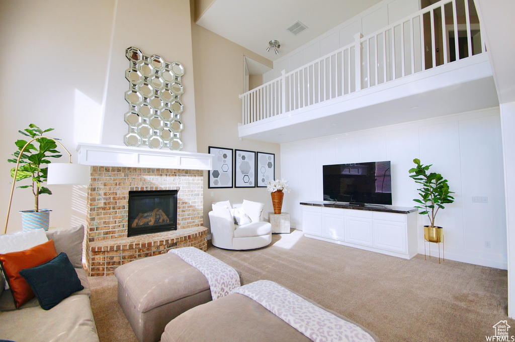 Carpeted living room featuring a high ceiling and a fireplace