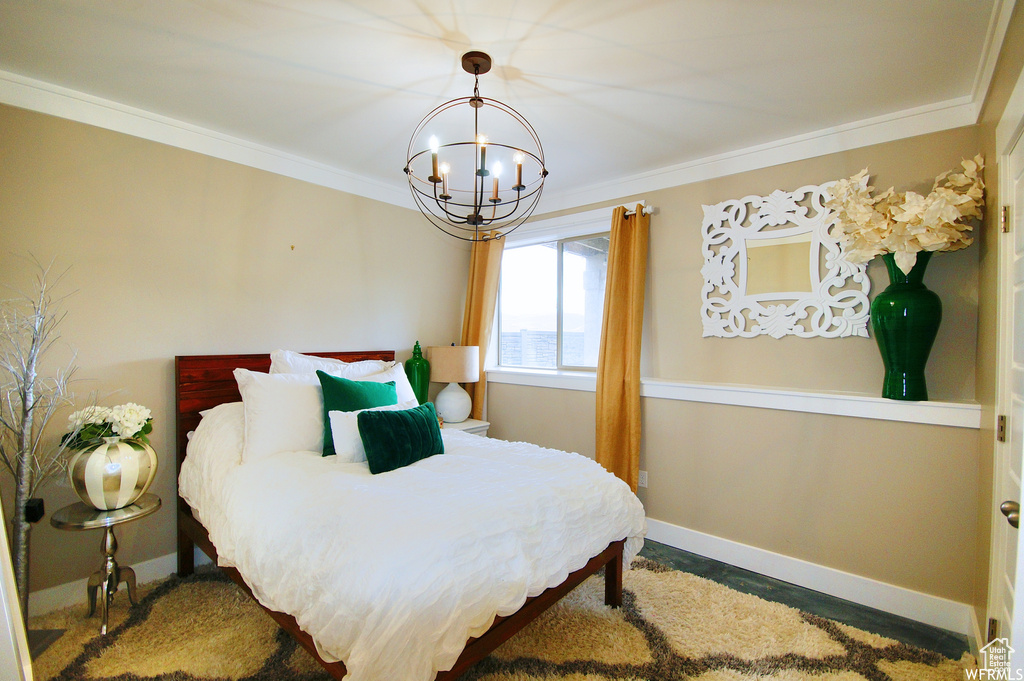Bedroom featuring an inviting chandelier and crown molding