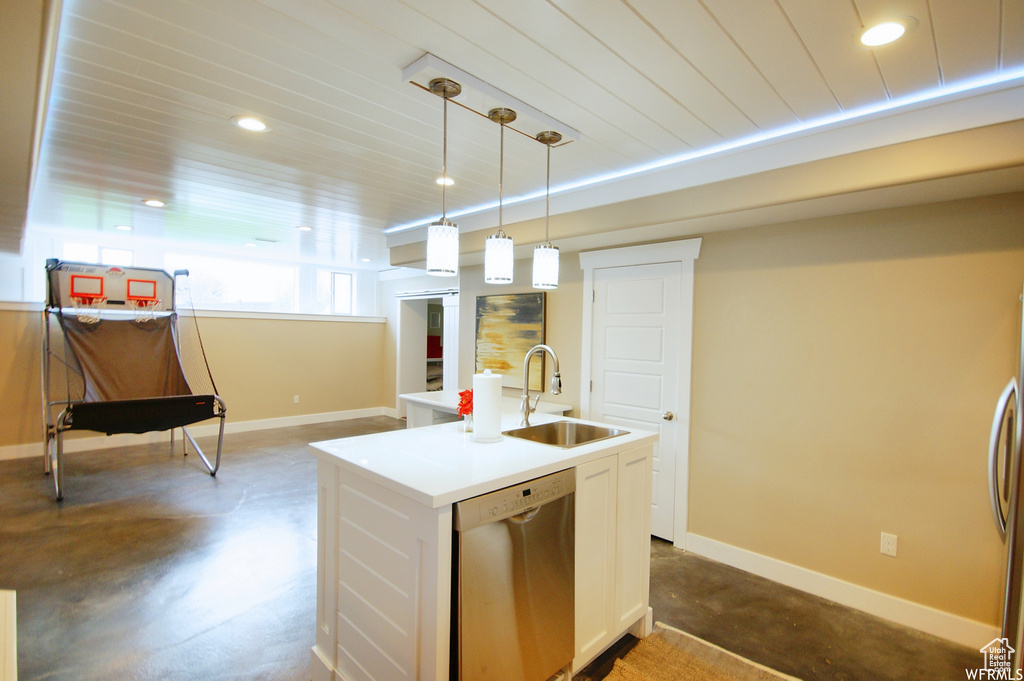 Kitchen featuring white cabinetry, sink, decorative light fixtures, an island with sink, and stainless steel appliances