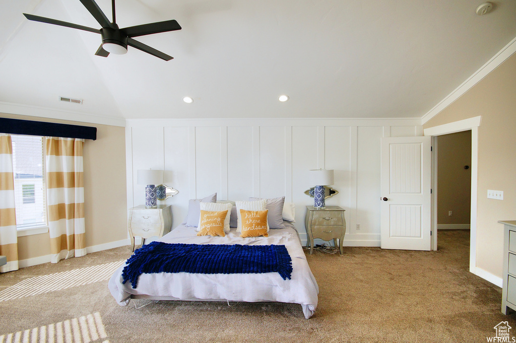 Carpeted bedroom featuring vaulted ceiling, crown molding, and ceiling fan