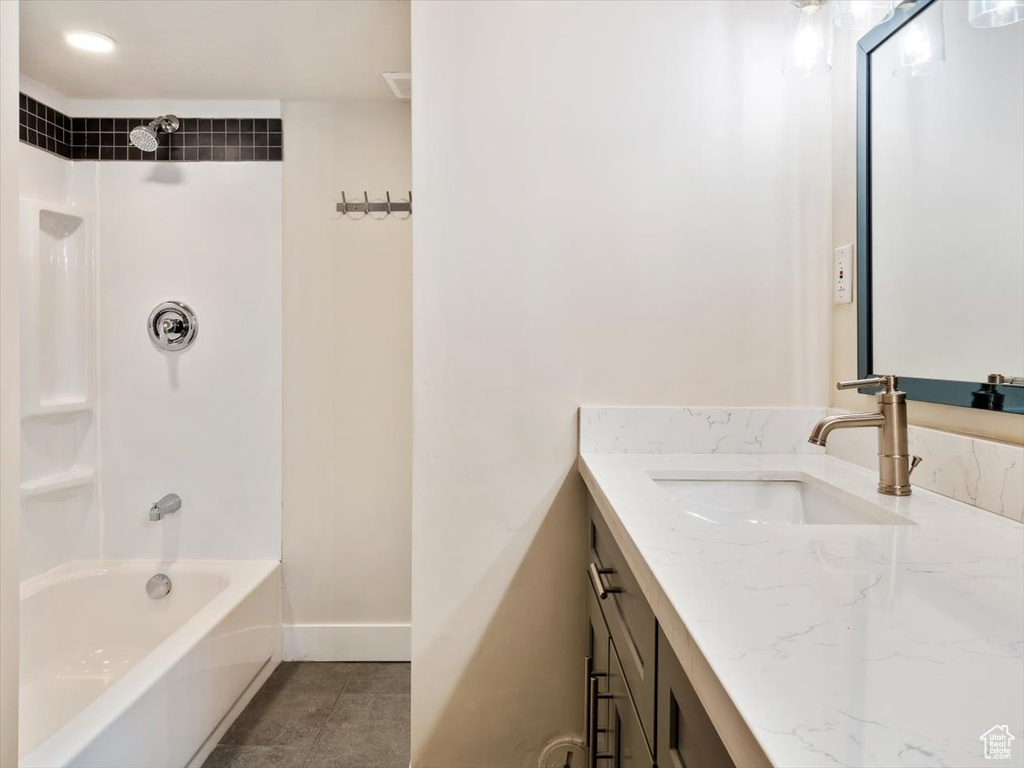 Bathroom featuring vanity, tile floors, and tiled shower / bath