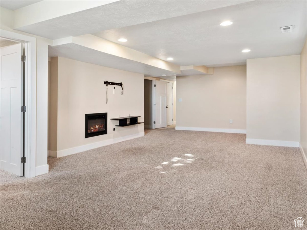 Unfurnished living room with a textured ceiling and light carpet