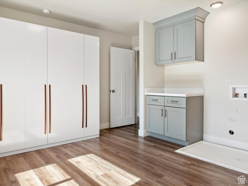 Interior space with hardwood / wood-style floors, hookup for a washing machine, and cabinets