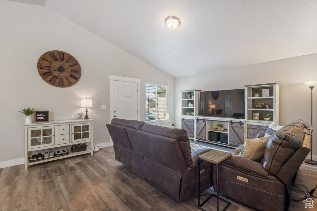 Living room featuring vaulted ceiling and dark hardwood / wood-style flooring