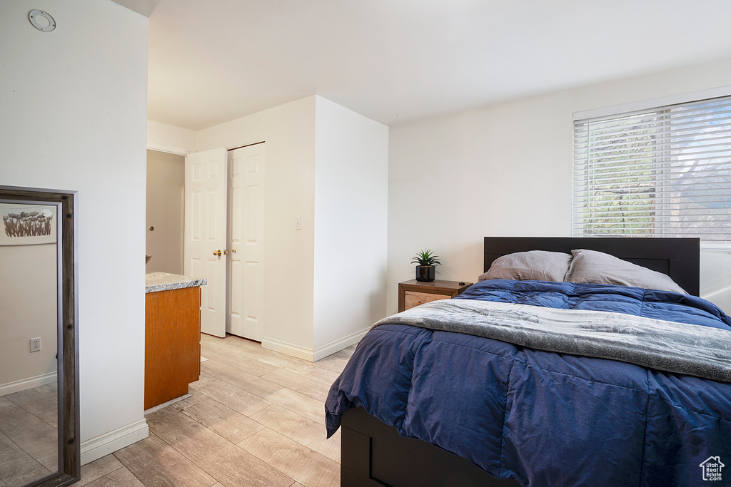 Bedroom with light hardwood / wood-style flooring and a closet