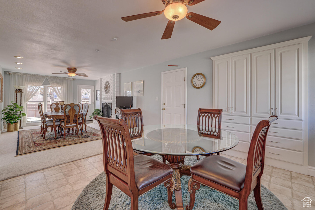 Carpeted dining area with ceiling fan