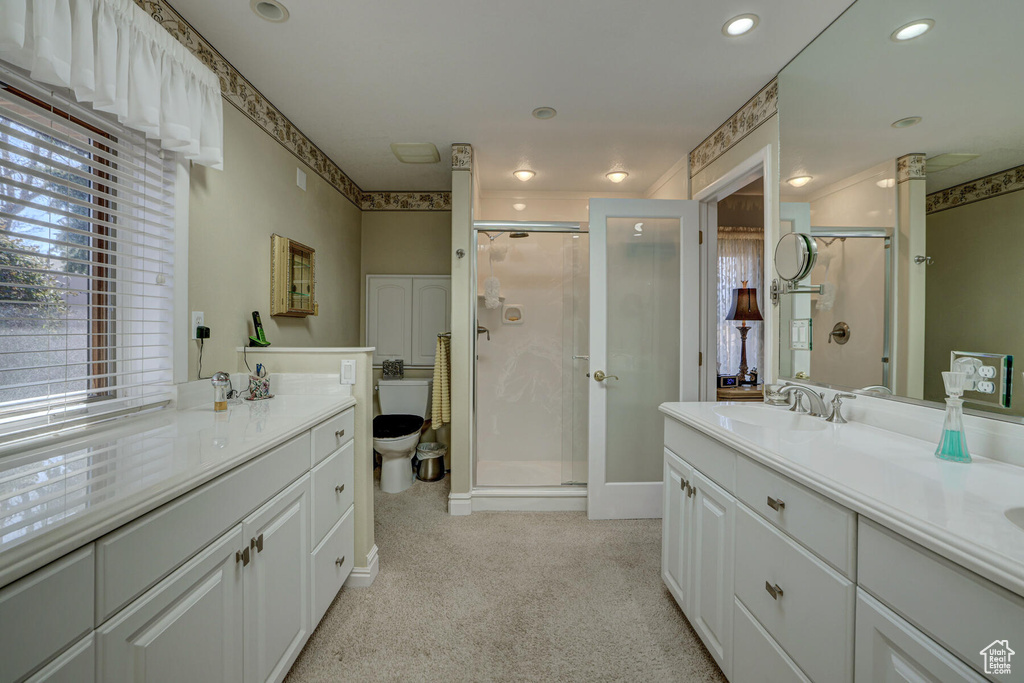 Bathroom with toilet, a shower with shower door, and oversized vanity