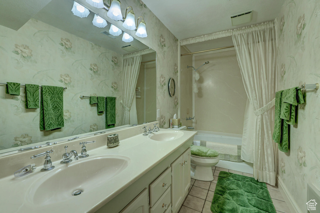 Full bathroom featuring dual sinks, tile floors, shower / tub combo, toilet, and oversized vanity