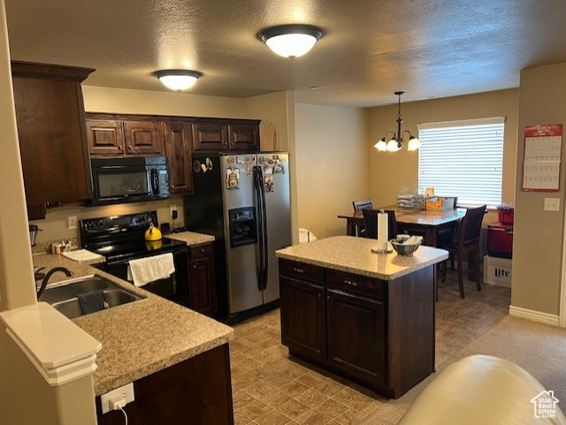 Kitchen featuring light colored carpet, a notable chandelier, hanging light fixtures, dark brown cabinets, and black appliances