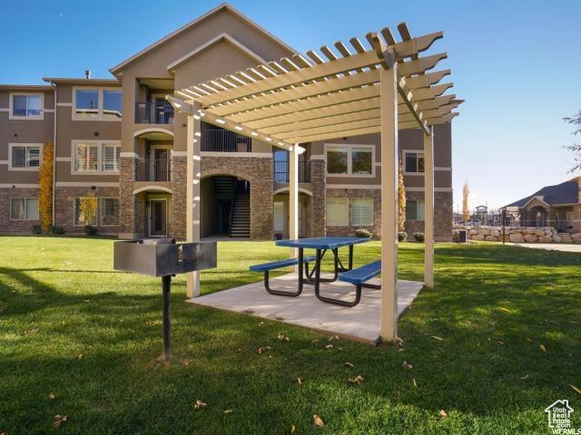 View of home\'s community with a pergola, a patio, and a yard