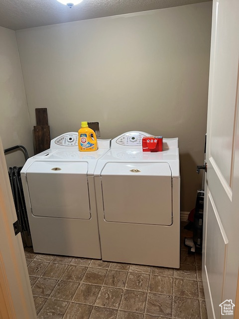 Laundry room with separate washer and dryer and dark tile flooring
