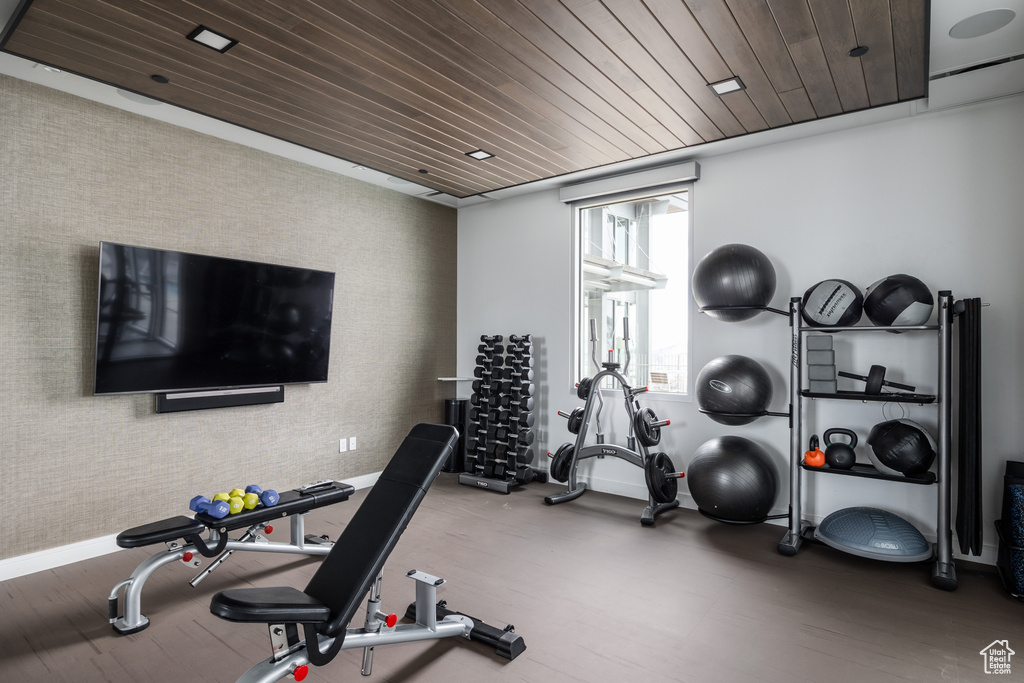 Exercise area featuring dark hardwood / wood-style flooring and wood ceiling