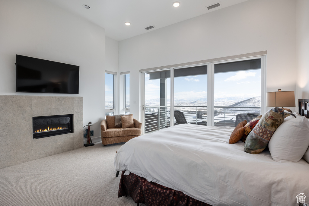 Bedroom with access to outside, a fireplace, and light carpet