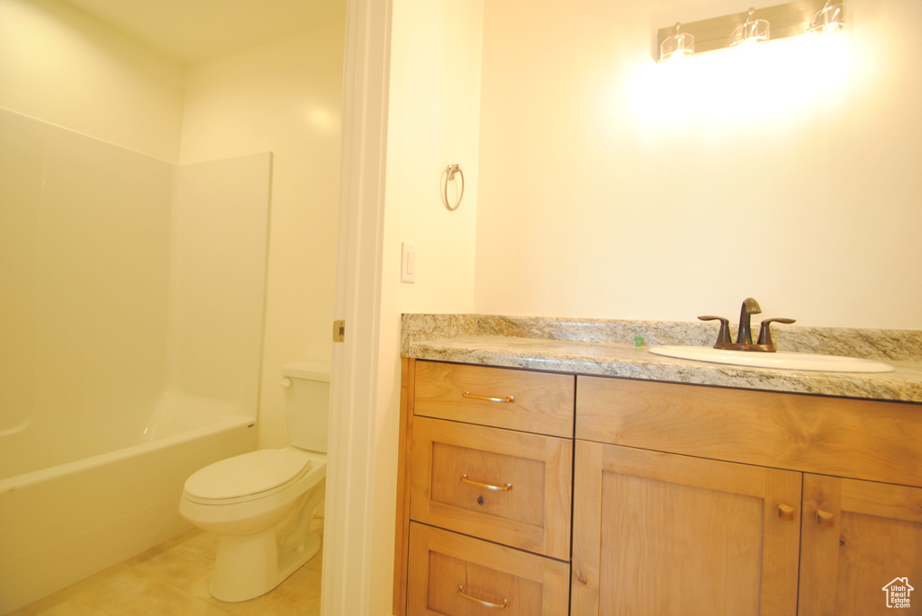 Full bathroom featuring vanity, toilet, tile flooring, and shower / bathing tub combination