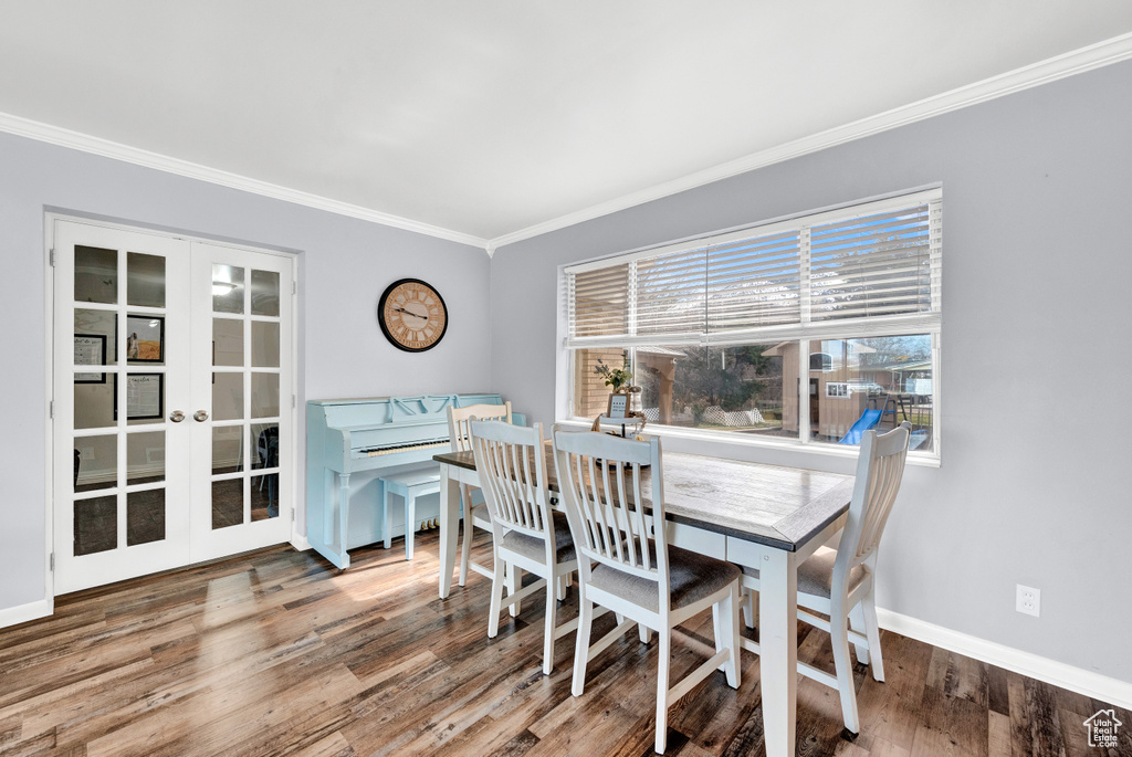 Dining space featuring french doors, crown molding, and dark wood-type flooring
