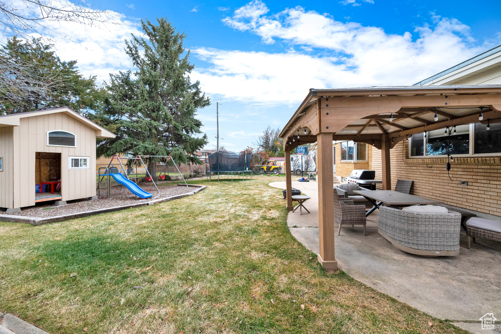 View of yard with a trampoline, a playground, a gazebo, an outdoor living space, and a patio