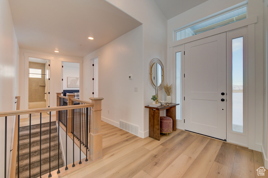 Entrance foyer with a wealth of natural light and light hardwood / wood-style floors
