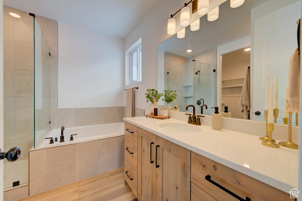 Bathroom featuring vanity, shower with separate bathtub, and hardwood / wood-style floors