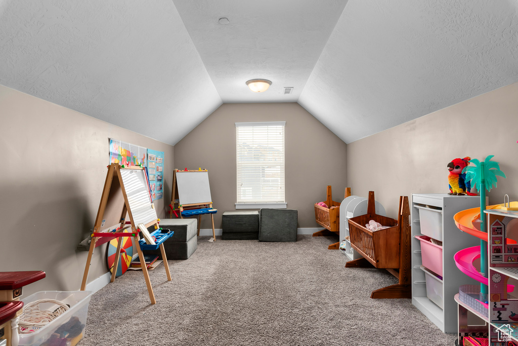 Rec room featuring light colored carpet and vaulted ceiling