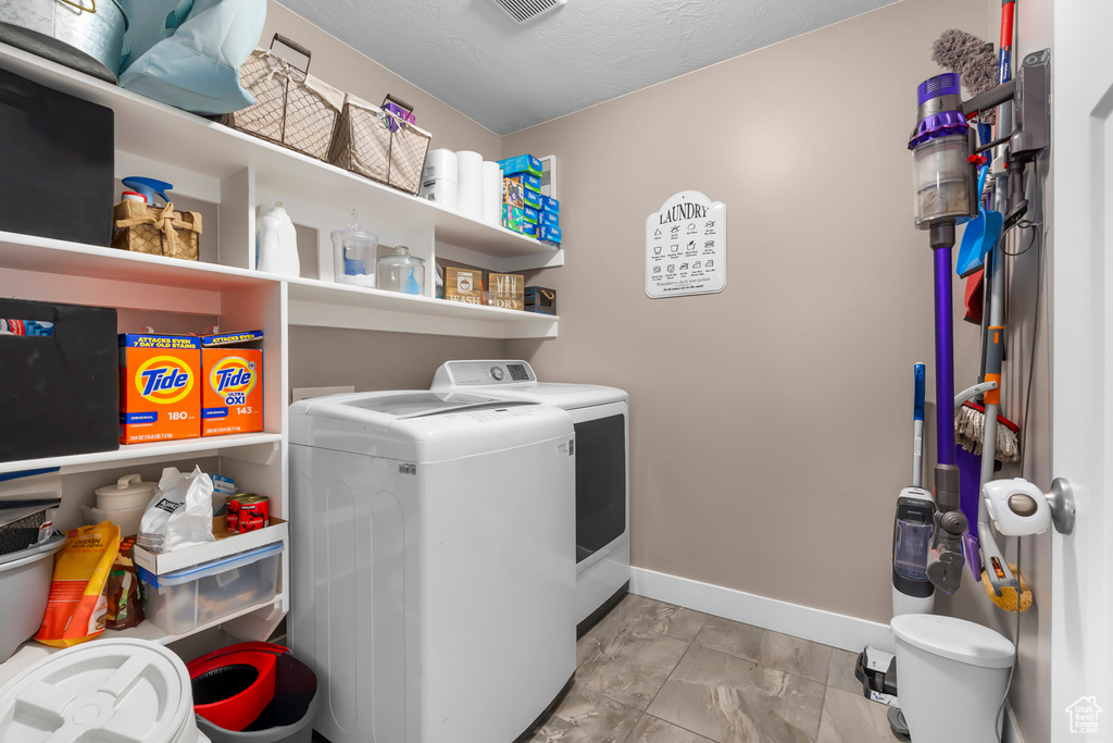 Laundry room featuring washing machine and clothes dryer and light tile floors