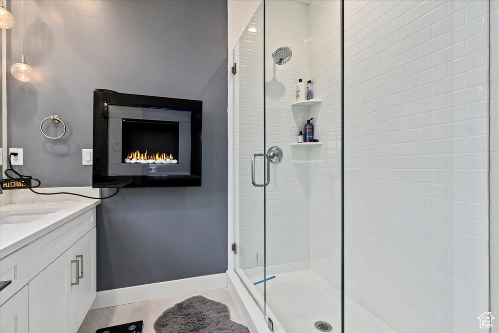 Bathroom featuring walk in shower, vanity, and tile floors