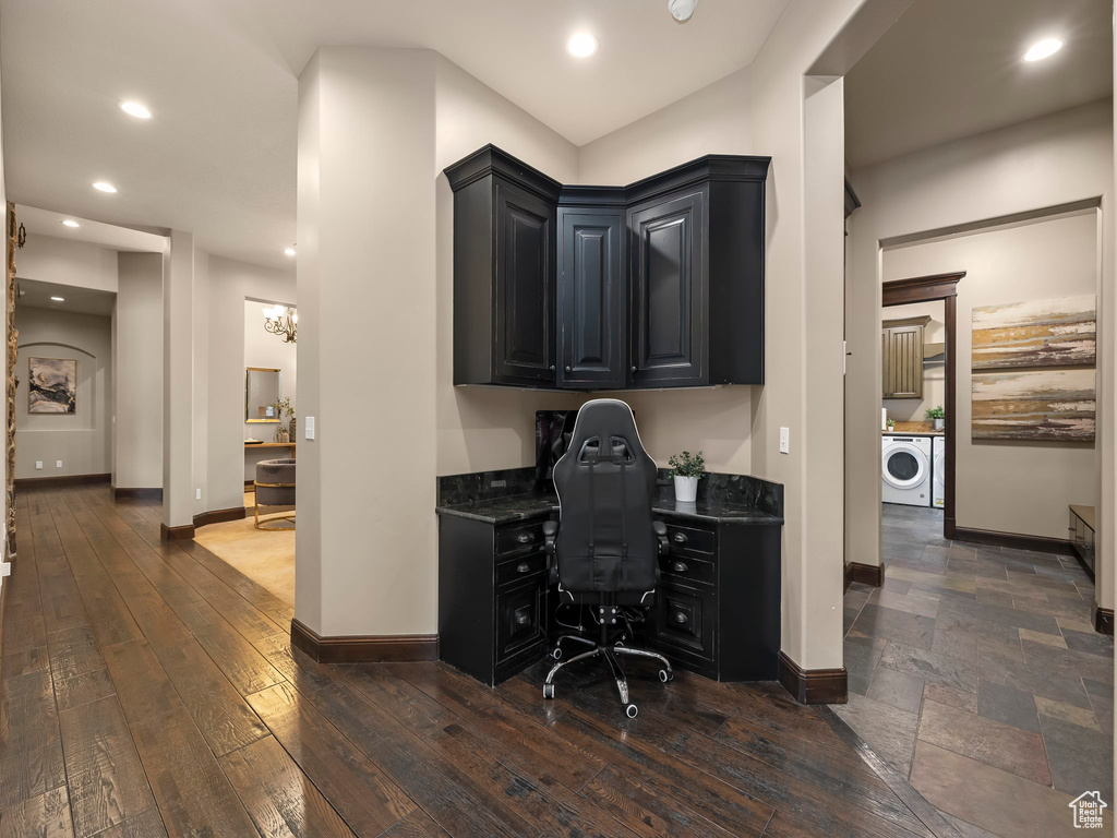 Office area featuring a notable chandelier, dark tile flooring, washer and dryer, and built in desk